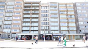 A multi-story residential building with balconies, a central courtyard, and outdoor shops. - Apartment in Nieuwpoort With sea View (Nieuwpoort)