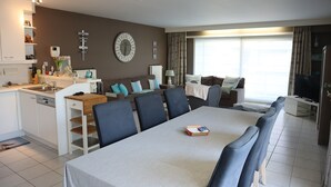 A modern living room with a dining area, a kitchen, and a TV. - Apartment in Nieuwpoort Near the Beach (Nieuwpoort)