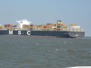 Un buque portacontenedores grande con el logo de MSC en el costado, navegando en el océano.