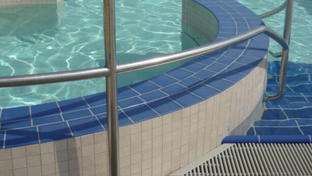 A swimming pool with a tiled edge and a metal railing. - North Sea Holiday House Wellmeyer (Wurster Nordseeküste)