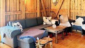 Une pièce rustique en bois, avec un canapé, une petite table et une chaise.