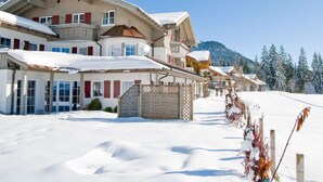 A large, multi-story building with a snow-covered roof and surrounding snow. - 2 in Alpenrosle Modern Retreat (Balderschwang)