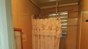 Un bagno piccolo con il water, un lavandino e una tenda per la doccia.
