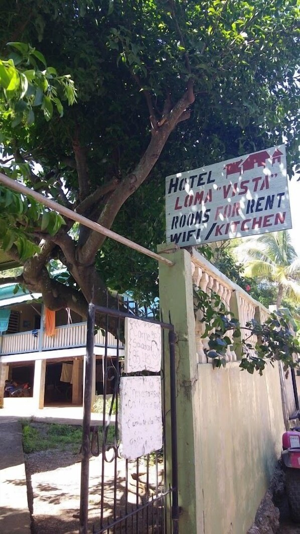 A sign advertising a hotel with rooms for rent, a kitchen, and WiFi. - Hotel Loma vista (Isla de Utila)