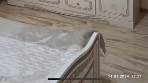A bedroom with a large white wardrobe, a bed, and a mirror.