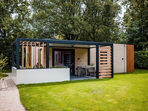 Relax in a serene outdoor space surrounded by lush greenery, featuring a seating area with a table and chairs.