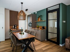 Cozy living space with a dining area, kitchenette, and sliding door to a separate room.