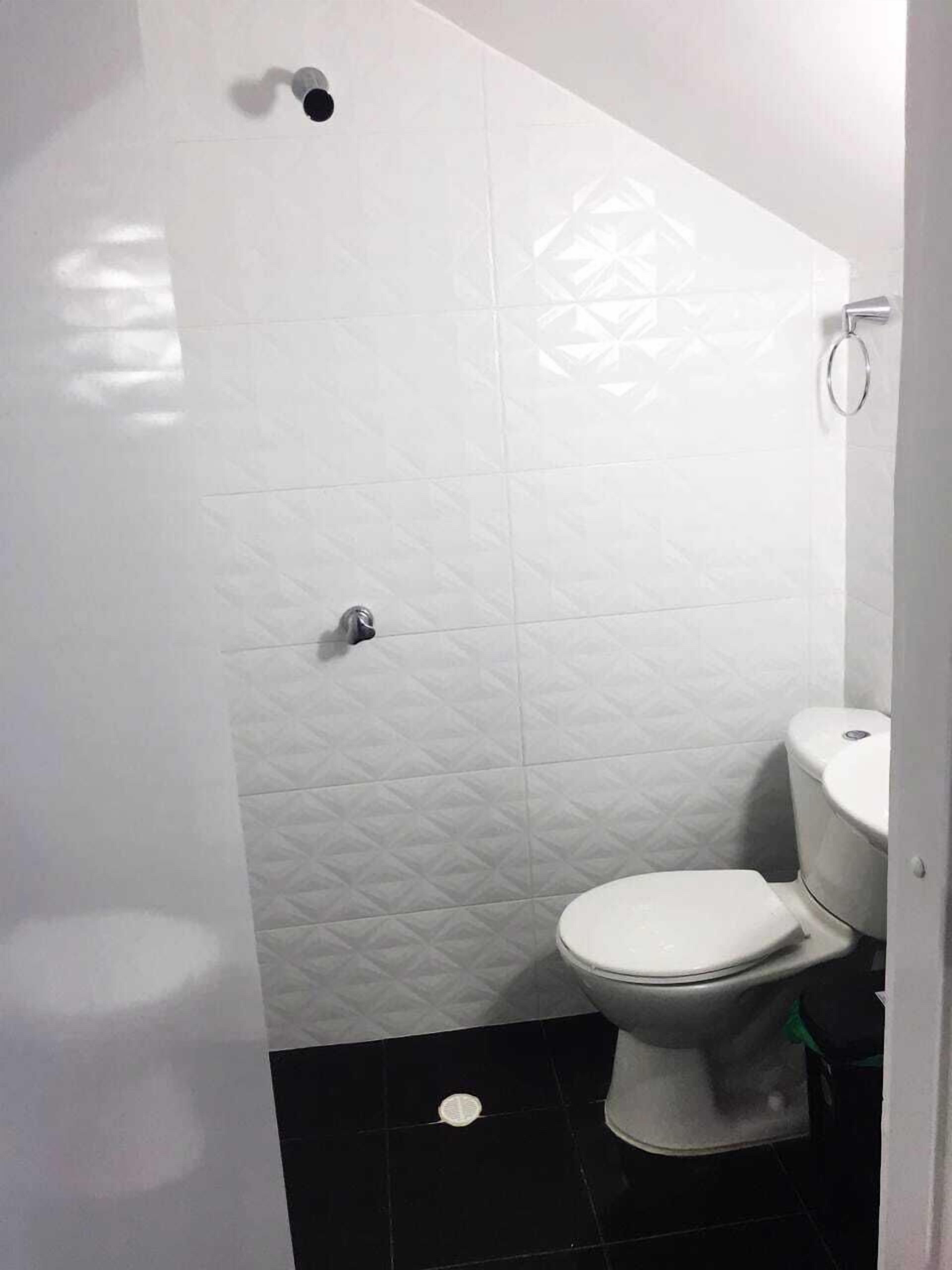 A bathroom with a toilet, a shower, and a sink.