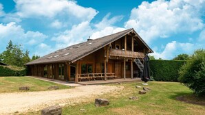 Une cabane en bois dotée d’un balcon, d’une véranda et d’un escalier menant à l’étage supérieur.