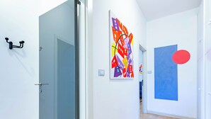 A hallway with a door, a wall-mounted art piece, and a blue painting. - Villino D'Agostino · Beachside 2-room villa flat, parking & 2 baths (Francavilla al mare)