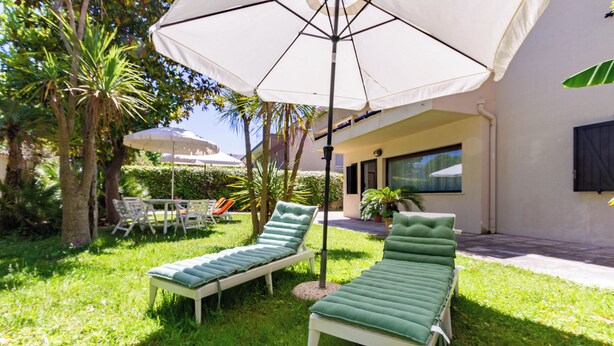 A patio with two lounge chairs, a table, and an umbrella. - Villino D'Agostino · Beachside 2-room villa flat, parking & 2 baths (Francavilla al mare)