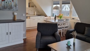 A modern apartment with a kitchen, dining area, and living room. - Kommodig Utkiek Modern Retreat (Zingst)