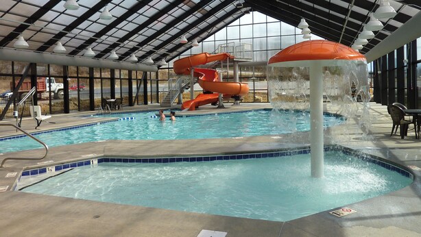 Une piscine intérieure dotée d’un toboggan et d’une fontaine.