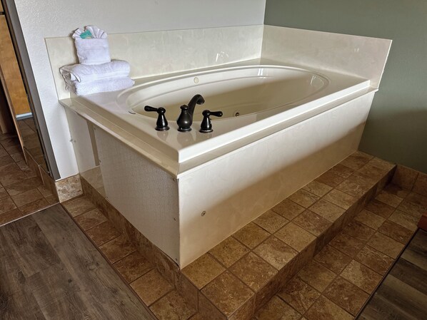 A modern bathroom with a freestanding bathtub, a towel rack, and a shower area. - Grand Smokies Resort Lodge (Pigeon Forge)