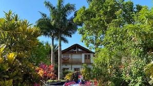 Un bâtiment à deux étages avec un jardin et un chemin qui mène à l’entrée.