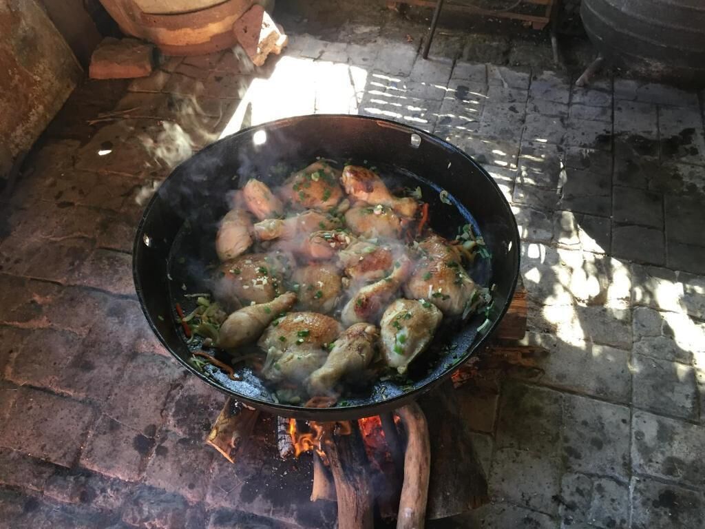 A large black pan filled with steaming dumplings on a stove.