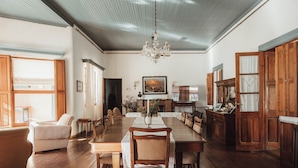 A spacious dining room with a long wooden table, surrounded by chairs, a chandelier, and wooden cabinets. - Estancia La Violeta (Chajarí)