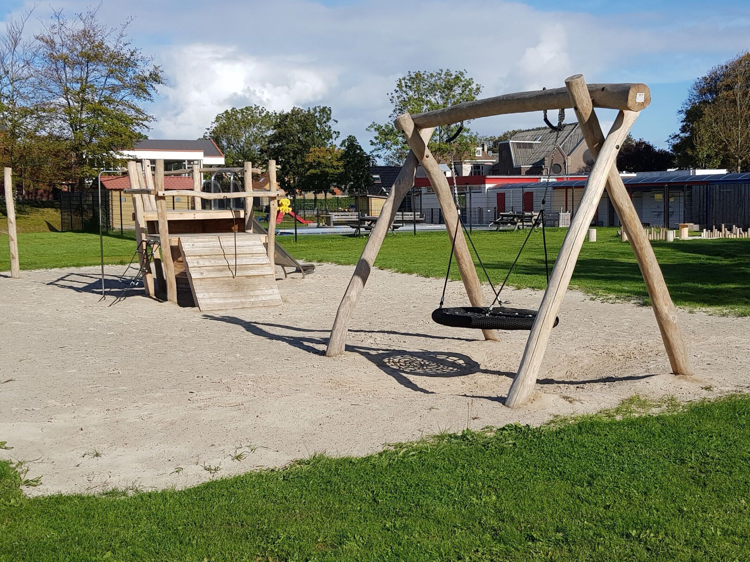 Een speelplaats met een schommel en een glijbaan.