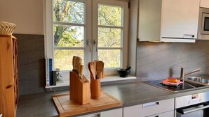 Una cocina moderna con un amplio ventanal, una tabla de cortar de madera y un lavabo.
