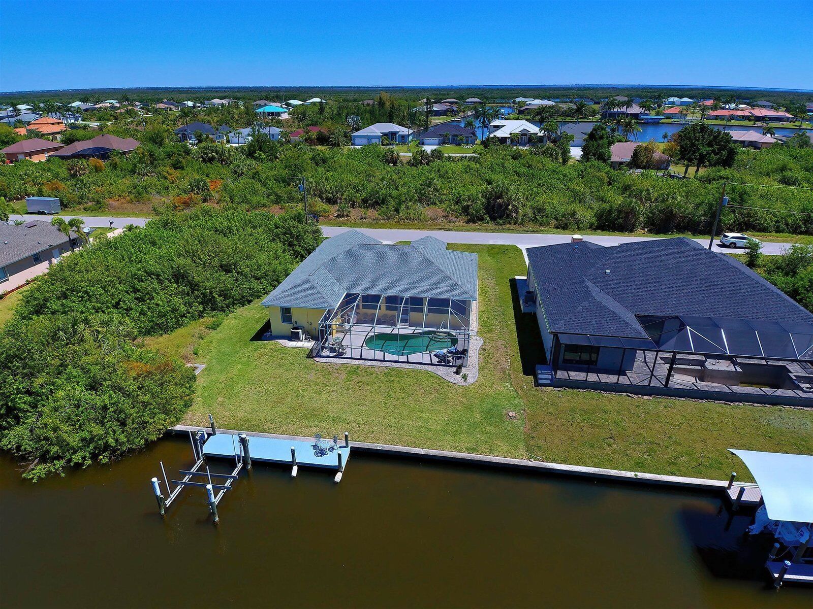 A residential area with houses, a swimming pool, and a dock.