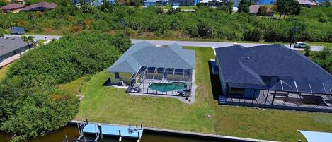 A residential area with houses, a swimming pool, and a dock.