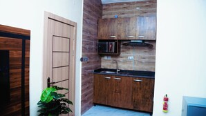 Una cocina con armarios de madera, microondas y fregadero.