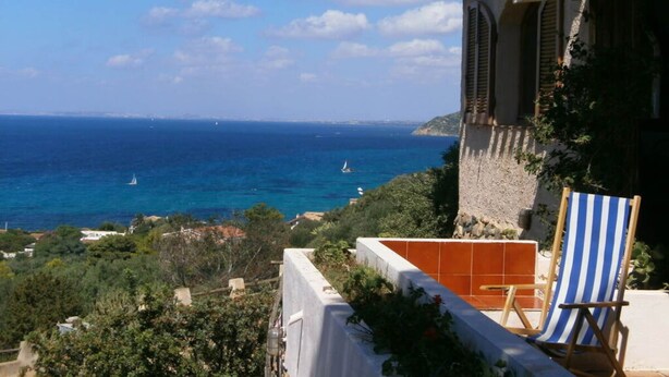 A seaside property with a terrace, a view of the sea, and a chair. - Donata Comfortable Holiday Residence (Maracalagonis)
