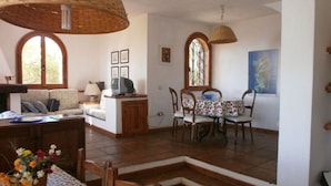 A cozy living room with a sofa, TV, and a dining area with a table and chairs. - Donata Comfortable Holiday Residence (Maracalagonis)