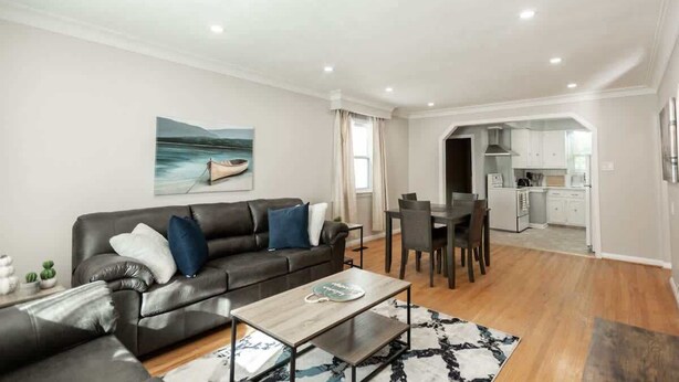 A modern living room with a sofa, coffee table, and dining area.