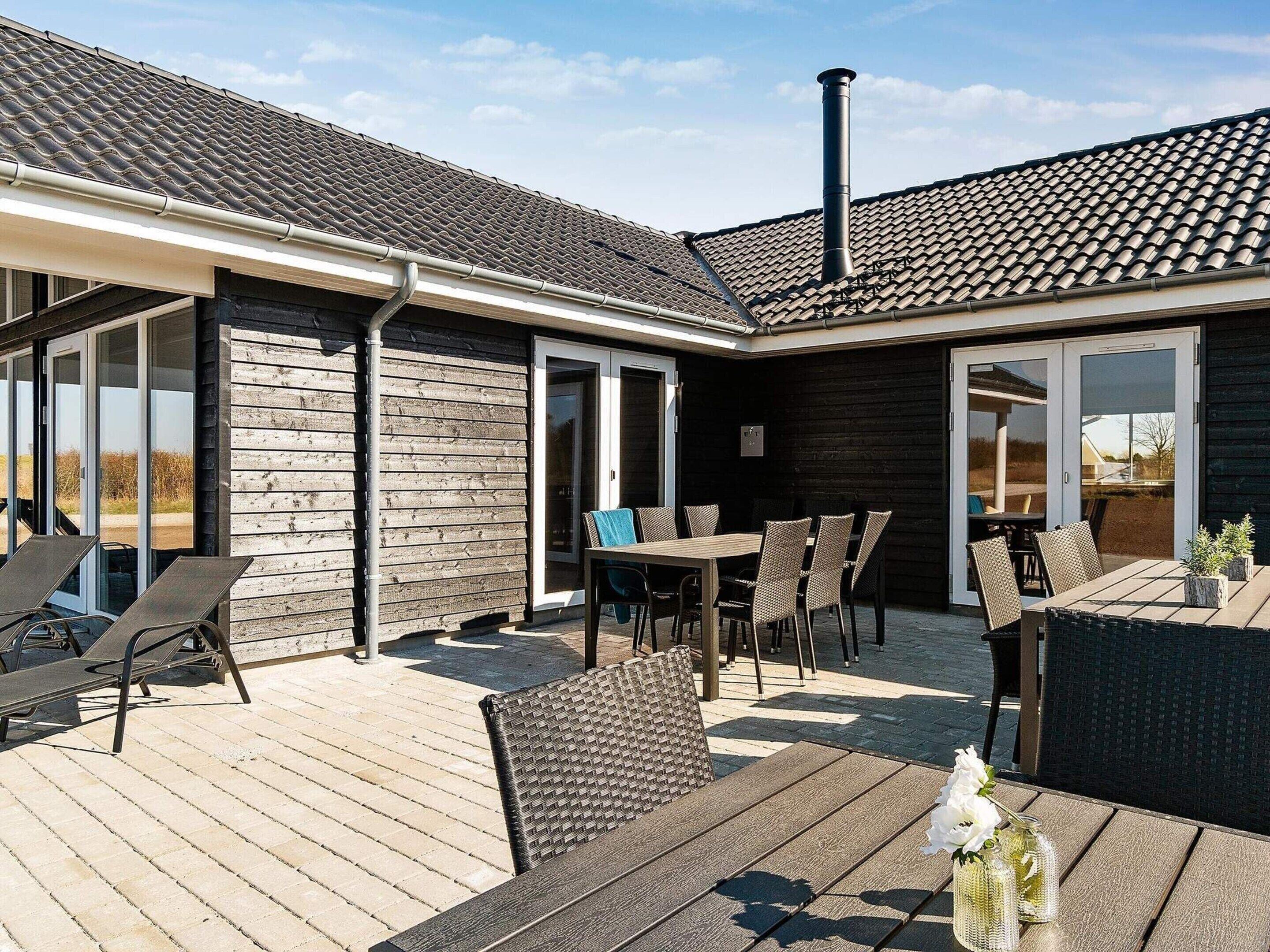 A patio area with a wooden deck, outdoor furniture, and a chimney.