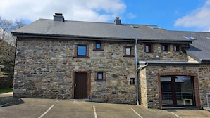 A stone building with a sloped roof, a central entrance door, and a small window. - Renovated Holiday Home in Stavelot With Infrared Sauna (Stavelot)