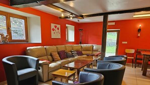 A living room with a sofa, chairs, a coffee table, and a dining table. - Renovated Holiday Home in Stavelot With Infrared Sauna (Stavelot)