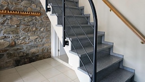 A staircase with stone walls and a wooden handrail. - Renovated Holiday Home in Stavelot With Infrared Sauna (Stavelot)