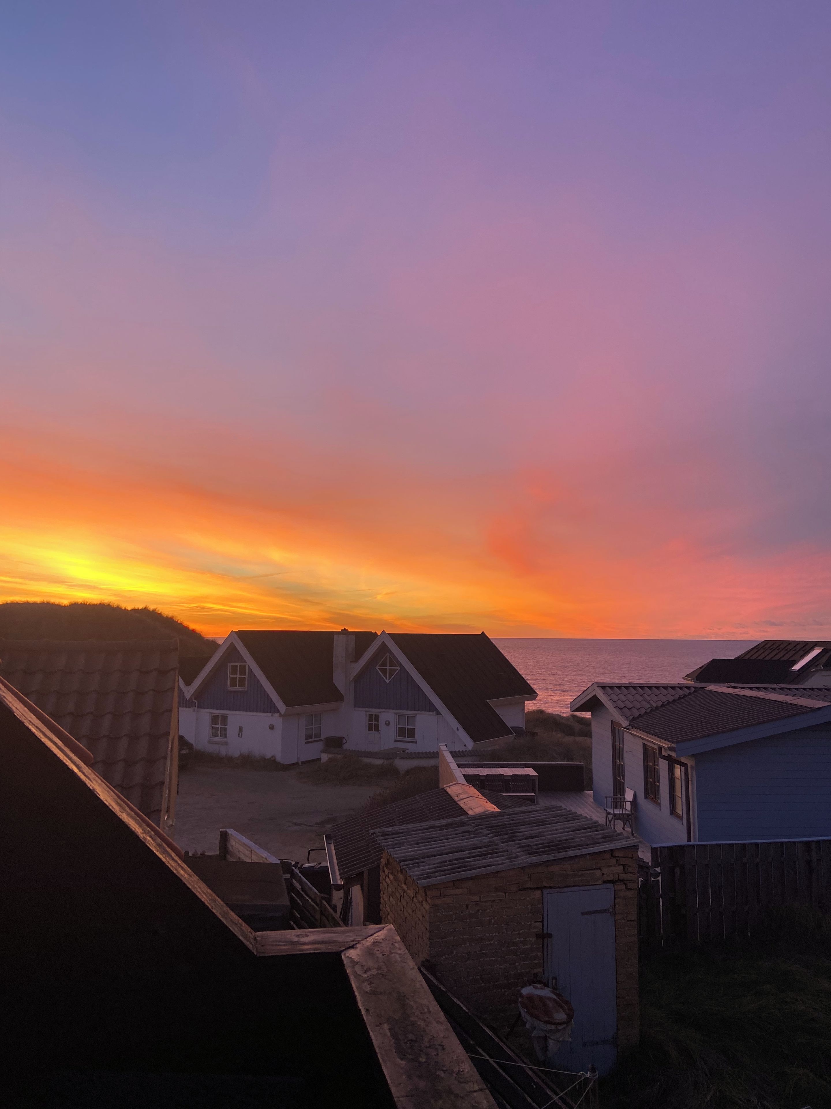 A coastal residential area with houses during sunset.