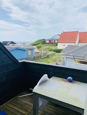 Un balcon avec vue sur les maisons et la mer.