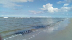 A beach with waves approaching the shore. - Dinkla 1 Comfortable Holiday Residence (Dornum)