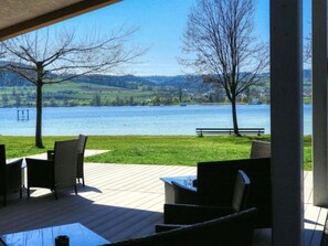A covered outdoor seating area with a view of a lake and hills. - Pleasant Apartment With Terrace (Ohningen)