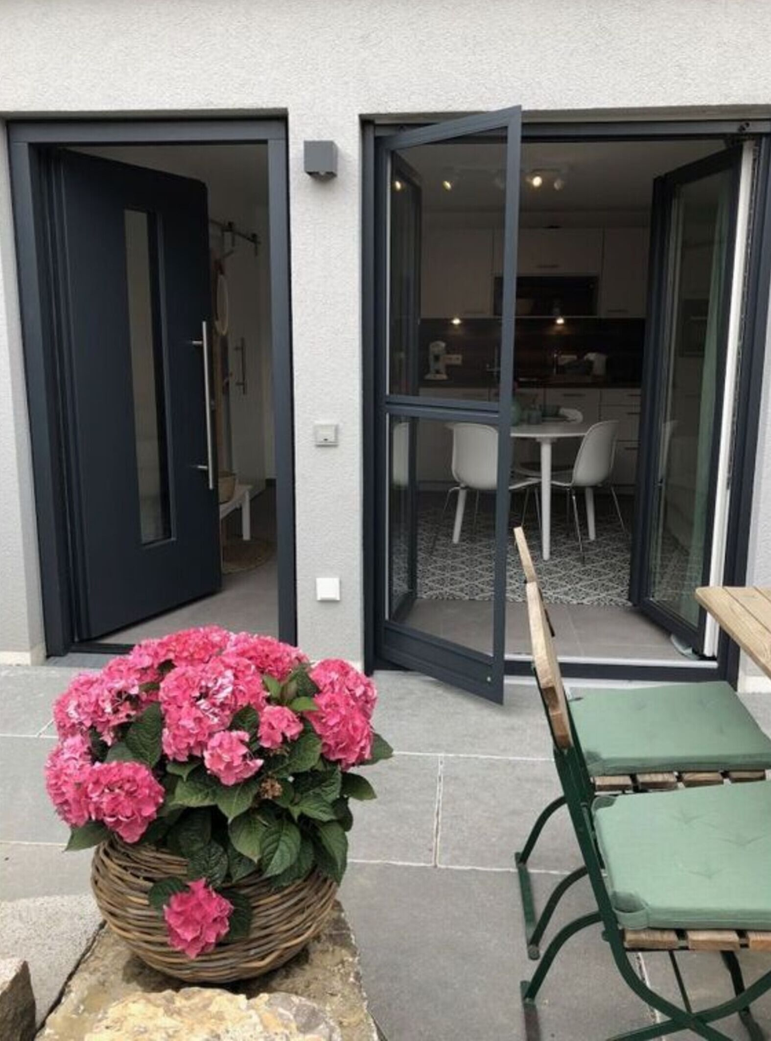 Un edificio moderno con puerta de vidrio que da a un comedor con mesa y sillas.