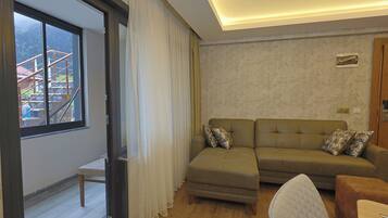 Suite supérieure, balcon, vue sur la montagne | Aire de séjour | Téléviseur