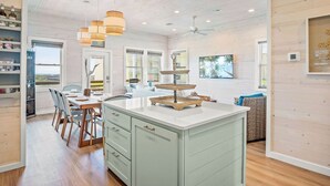 A spacious kitchen with a central island, wooden cabinets, and pendant lighting. - Private Pool|Steps to Beach|Ocean View (Port Aransas)