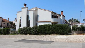 A two-story house with a white facade, red-tiled roof, and a chimney. - LUANA One-Bedroom Apartment with Balcony (Rovinj)