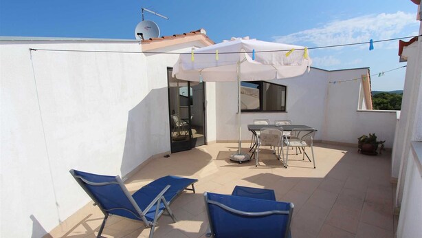 A rooftop patio with a table and chairs, a white umbrella, and blue lounge chairs. - LUANA One-Bedroom Apartment with Balcony (Rovinj)