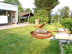 A modern outdoor area with a wooden deck, a metal grill, and a lounge chair. - Holiday Home Foresight (Heilbad Heiligenstadt)