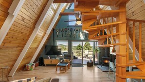 A loft-style room with a wooden ceiling, a fireplace, a television, and a view of the outdoors. - Indigo //Aframe- Hot Tub- Views! (Divide)