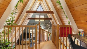 A wooden attic room with a sloped ceiling, a wooden staircase, and a window. - Indigo //Aframe- Hot Tub- Views! (Divide)