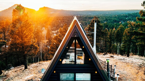 A triangular cabin with a view of a forested landscape and a mountain in the distance. - Indigo //Aframe- Hot Tub- Views! (Divide)