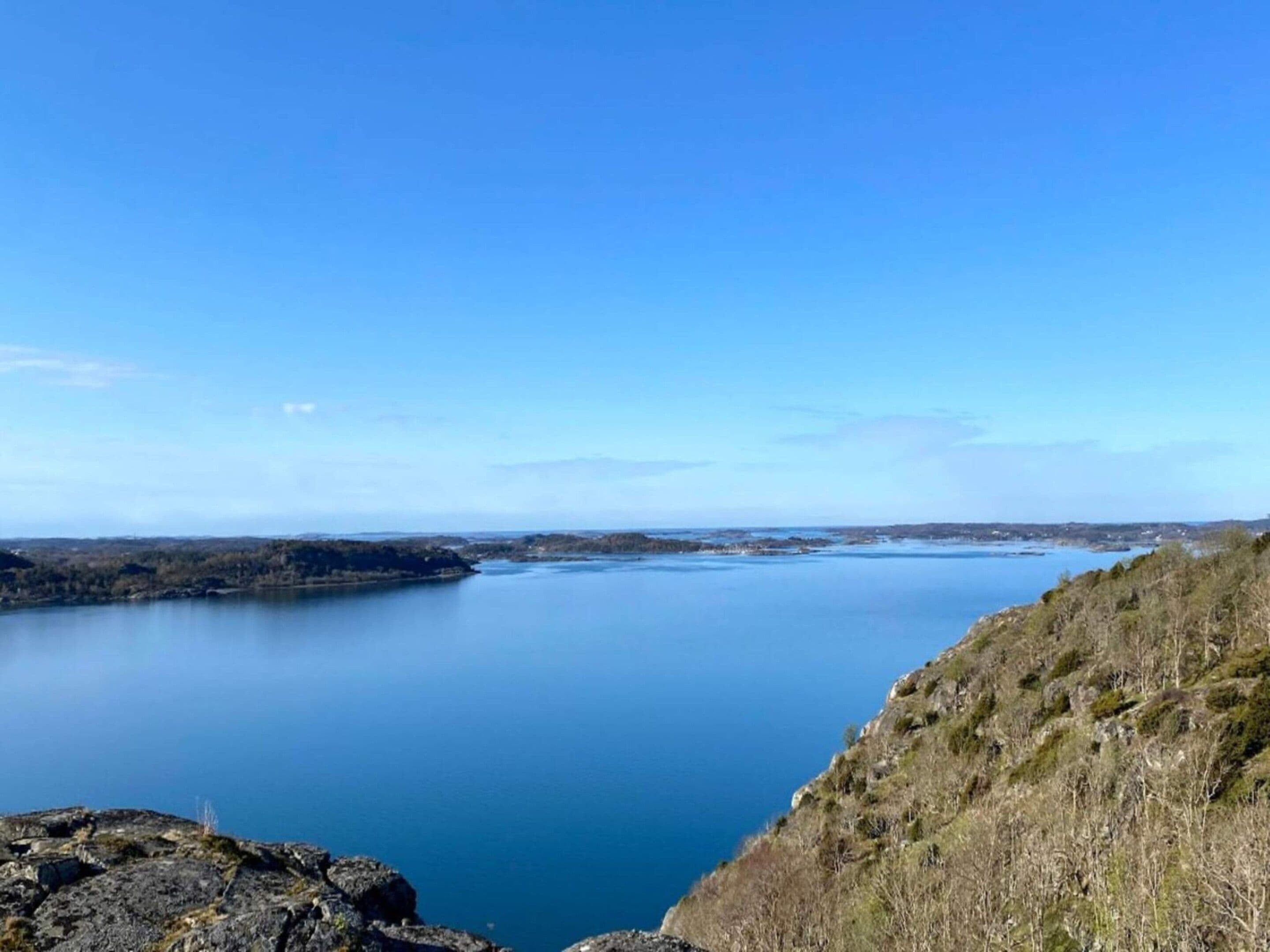 Een panoramisch uitzicht over een helder meer, omgeven door heuvels en schaarse begroeiing.