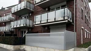 A modern apartment building with multiple balconies and a gated entrance. - Pink Cow Modern Retreat (Groemitz)