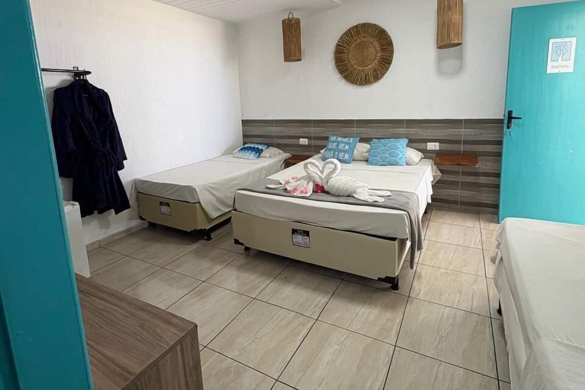 A room with two beds, a wardrobe, and a door.