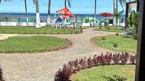 A pathway leading to a beach area with palm trees and umbrellas. - Pousada Villa Mar Porto (Ipojuca)